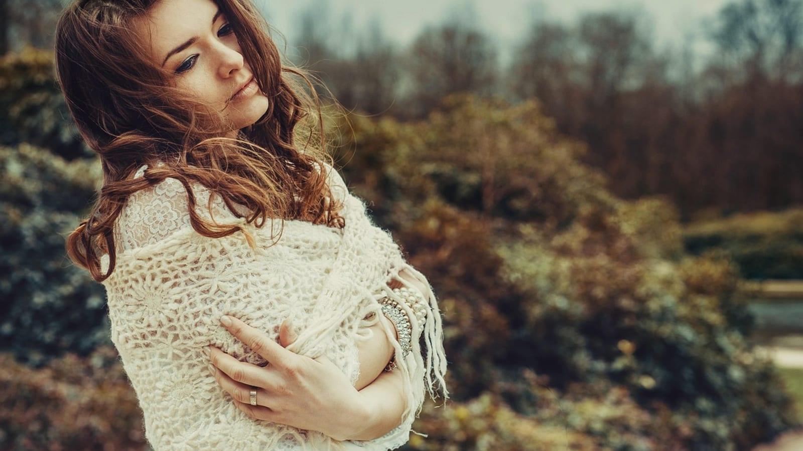 Smiling woman with long defined curly brown hair, natural light