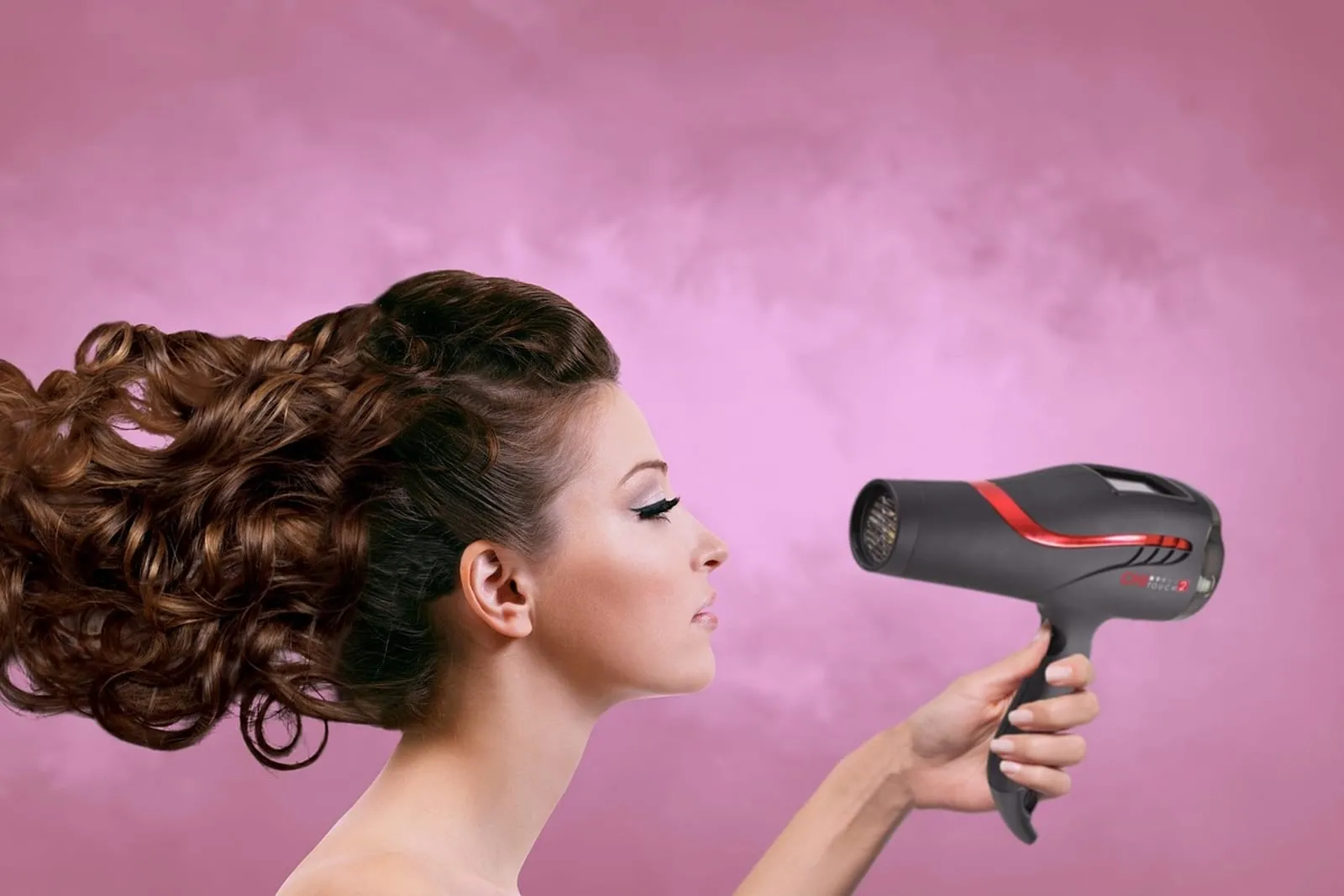 Woman blow-drying her hair seen from the side