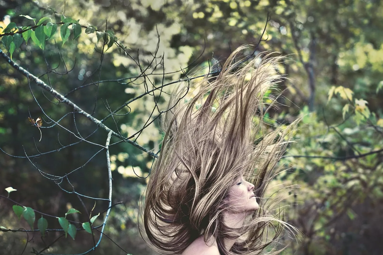 Woman with long brown hair flipping in motion, action shot