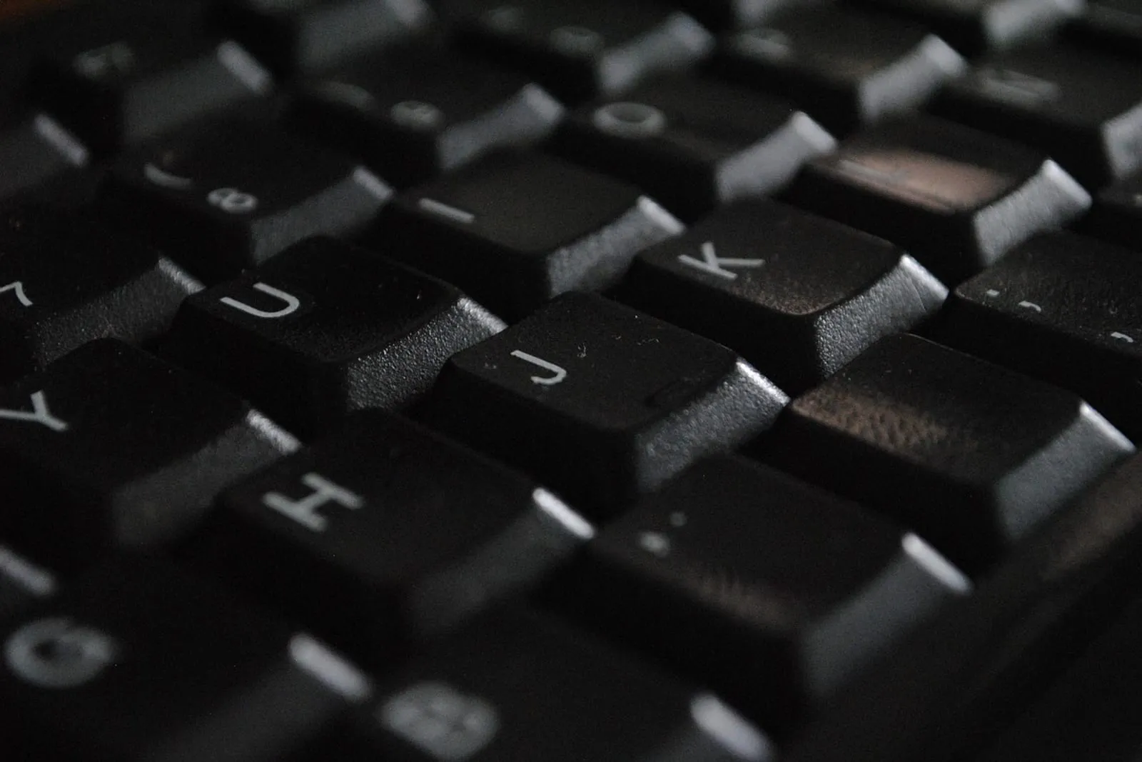 Macro shot of black laptop keys showing the narrow gaps between them