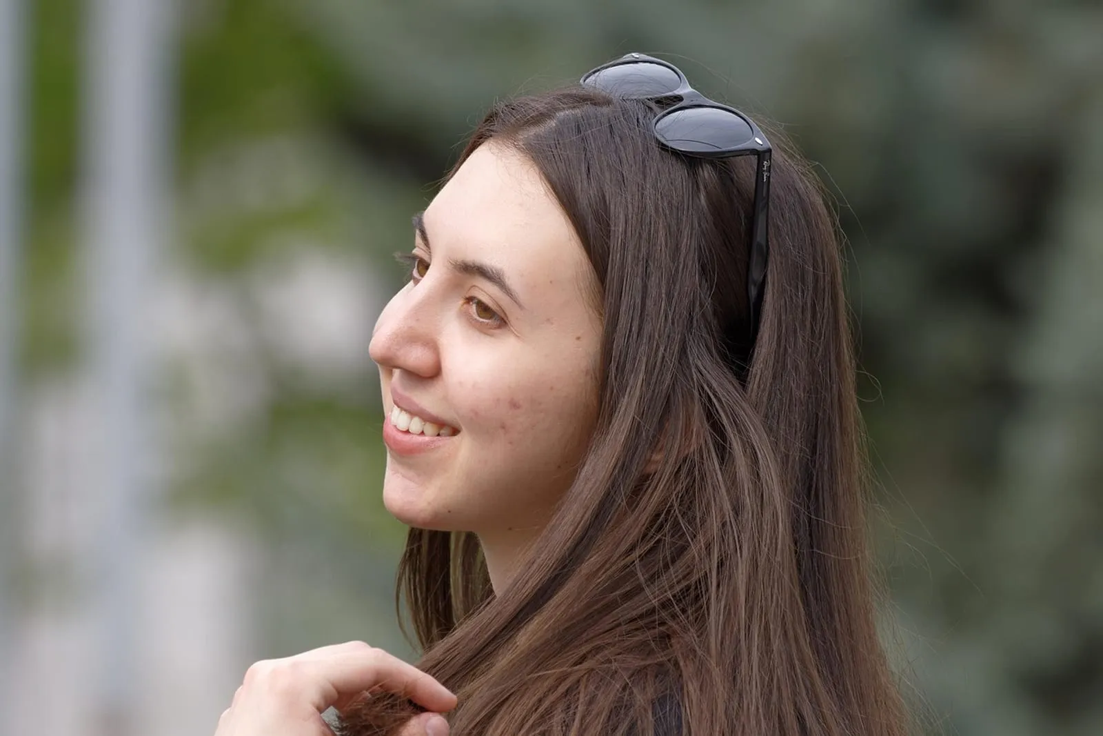 Woman running her hand through her hair outdoors