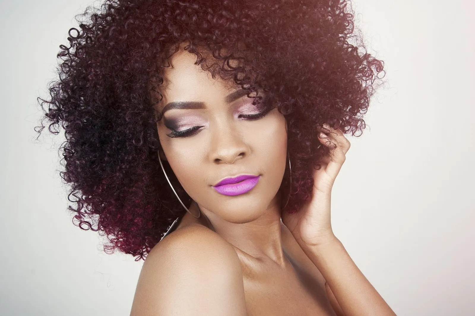 Woman with defined curly hair after washing, soft daylight