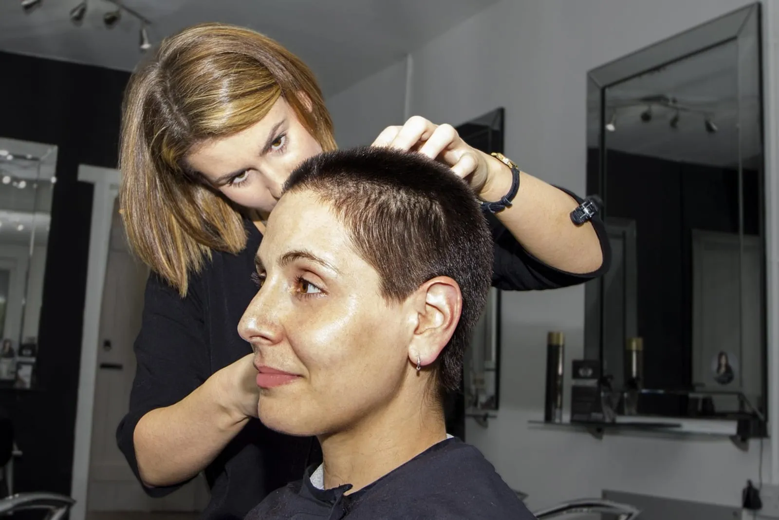Hairdresser in a salon styling a client's long hair