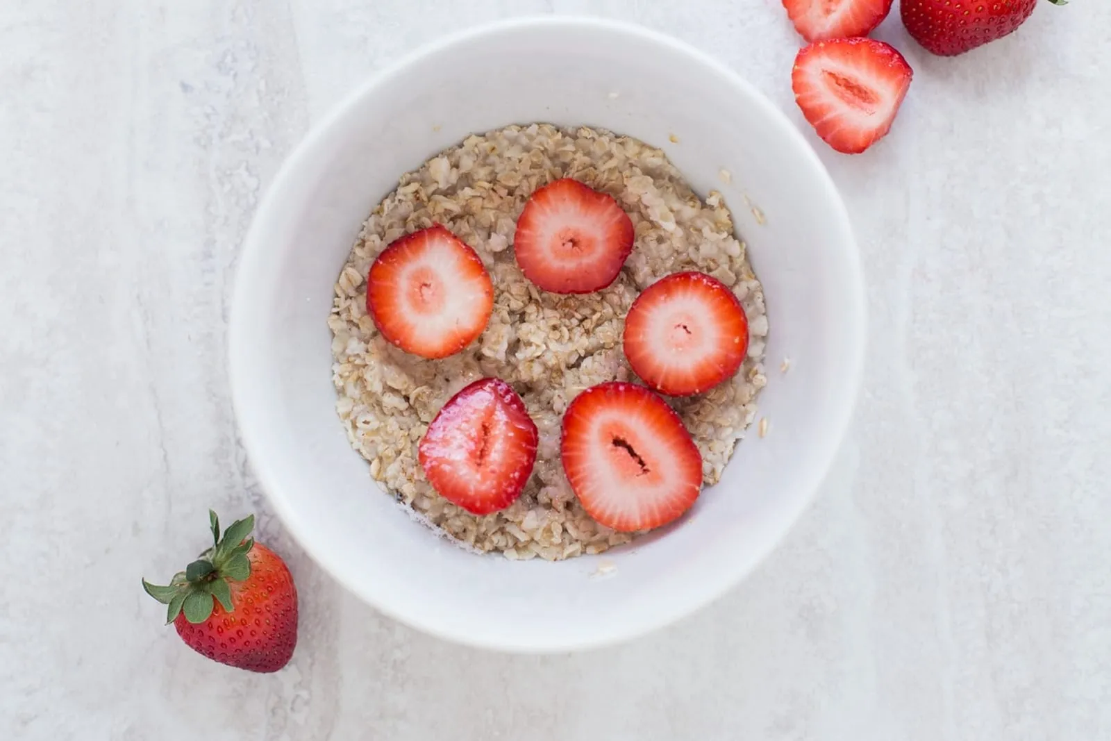 Bowl of oatmeal topped with fresh strawberries